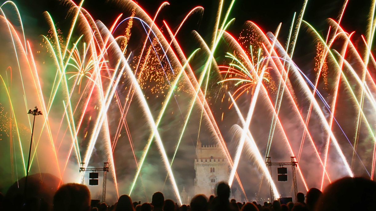 Fireworks display near Belém Tower in Lisbon at night.