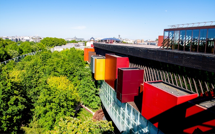 Musee du Quai Branly exterior with colorful facade and lush greenery in Paris.