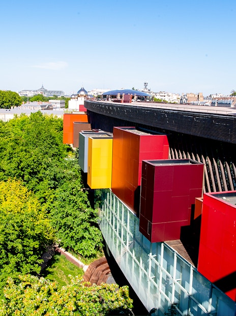 Musee du Quai Branly exterior with colorful facade and lush greenery in Paris.