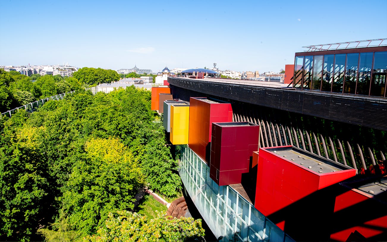 Musee du Quai Branly exterior with colorful facade and lush greenery in Paris.