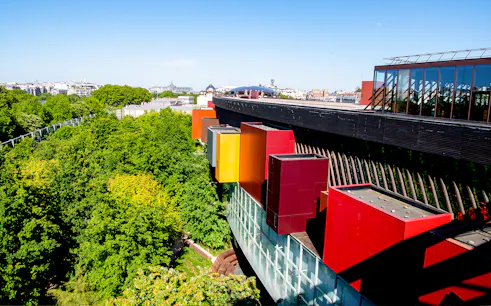 Musee du Quai Branly exterior with colorful facade and lush greenery in Paris.