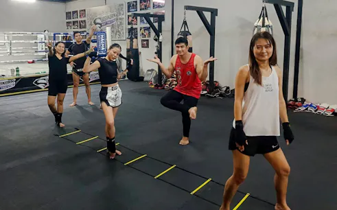Beginners practicing Muay Thai techniques in a Pattaya gym.