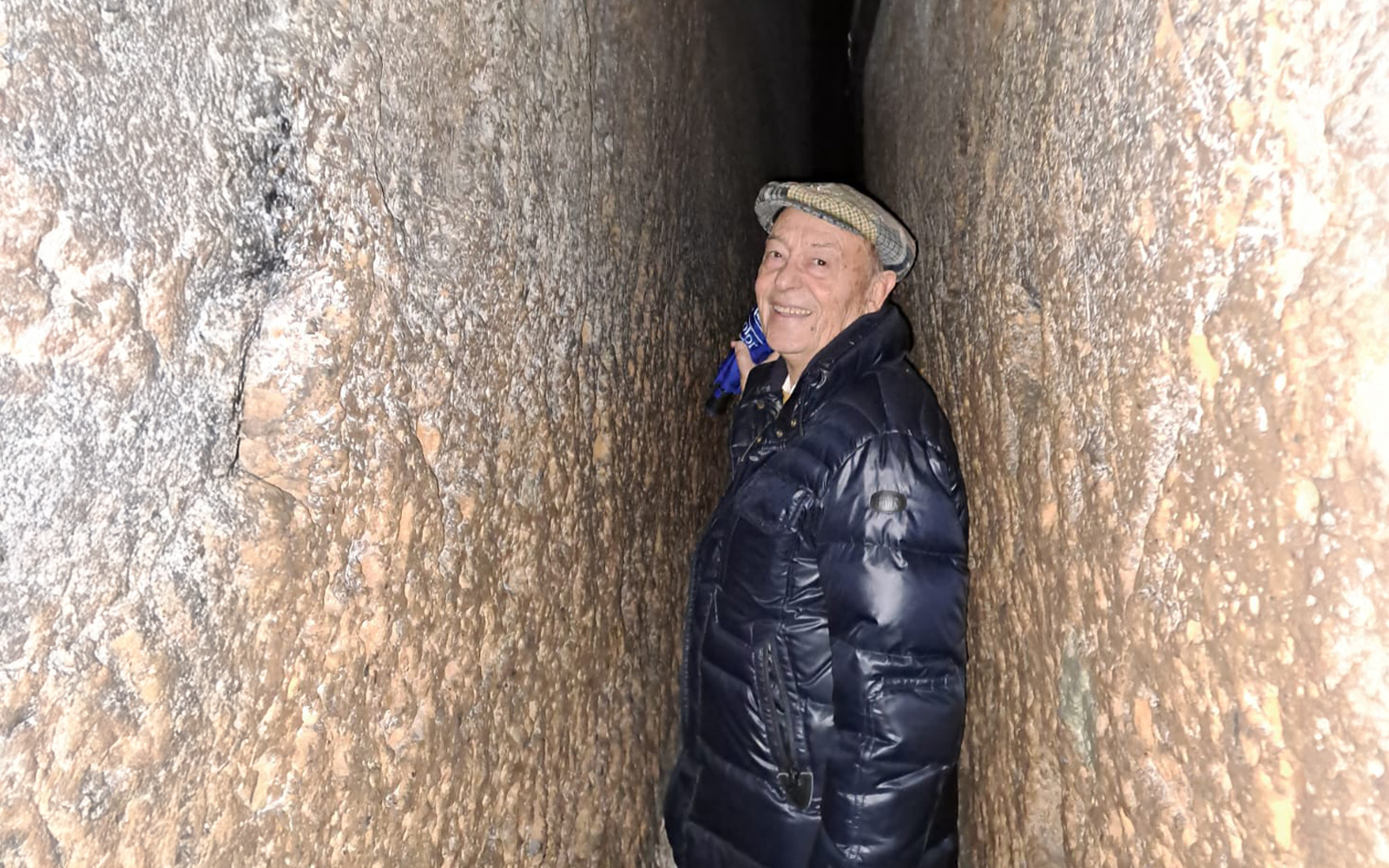 Visitor navigating narrow tunnel in Napoli Sotterranea.