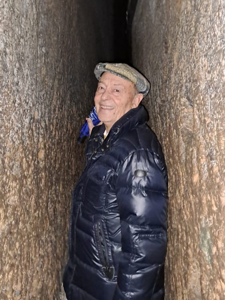 Visitor navigating narrow tunnel in Napoli Sotterranea.