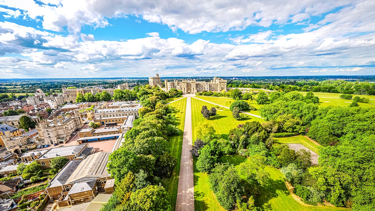 Aerial view of Windsor Castle surrounded by lush green landscape in England.