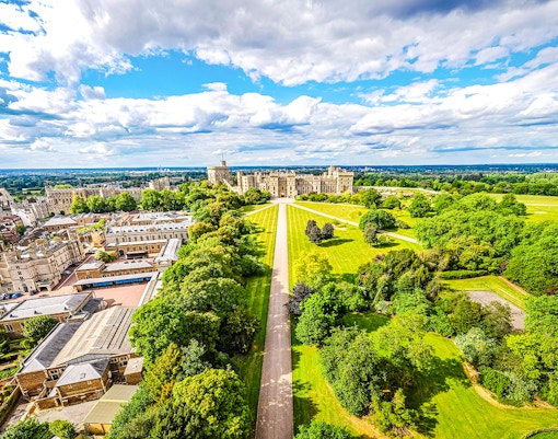 Aerial view of Windsor Castle surrounded by lush green landscape in England.