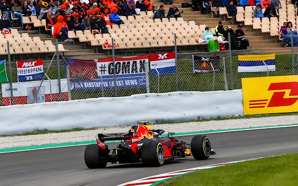 Race car on track at Barcelona F1, Main Grandstand in background.