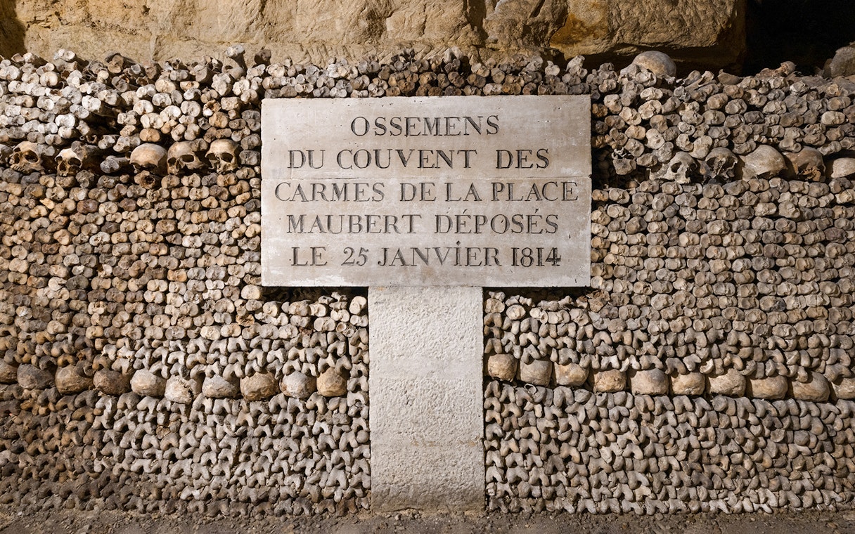 Catacombs’ Ossuary wall of bones with inscription, Paris.