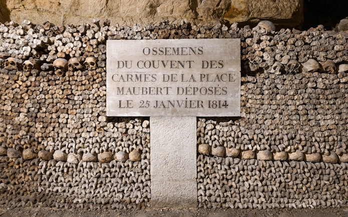 Catacombs’ Ossuary wall of bones with inscription, Paris.