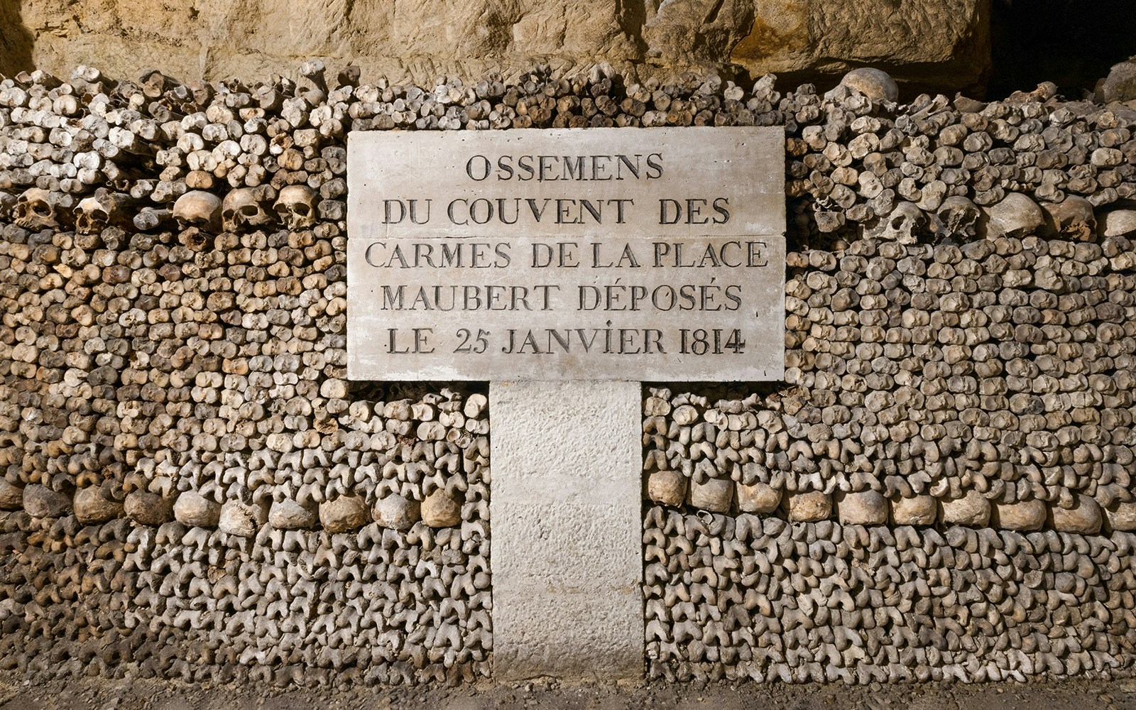 Catacombs’ Ossuary wall of bones with inscription, Paris.