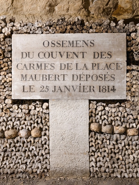 Catacombs’ Ossuary wall of bones with inscription, Paris.