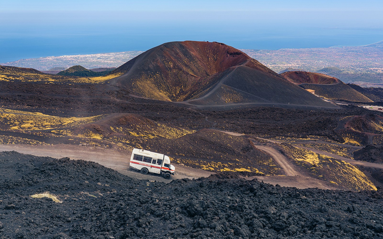 4x4 mini bus traversing Mount Etna's rugged terrain, Catania, Italy.