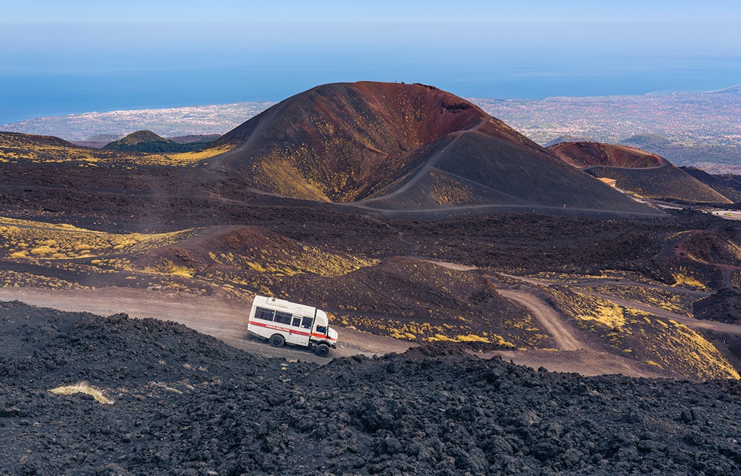 4x4 mini bus traversing Mount Etna's rugged terrain, Catania, Italy.