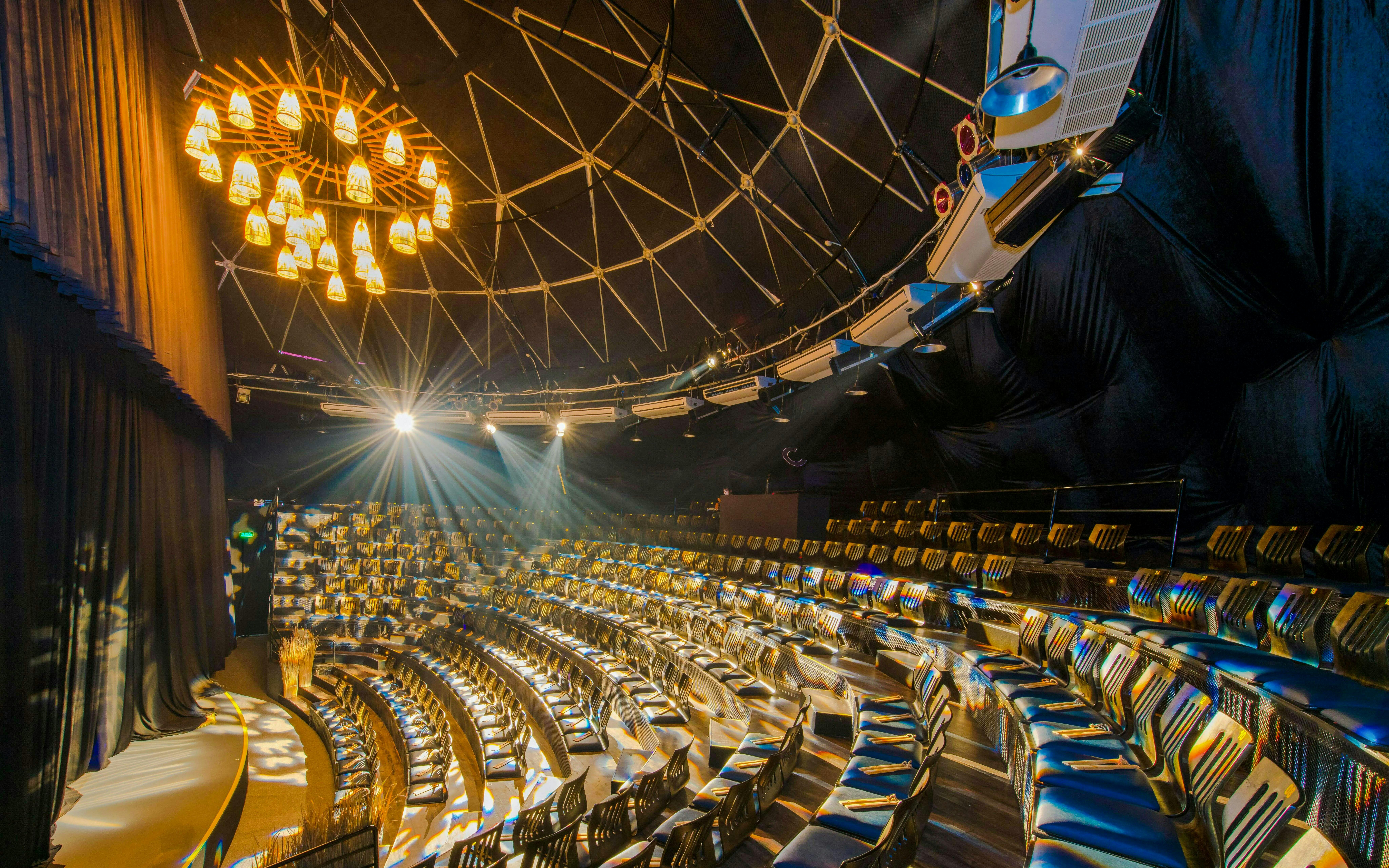 Teh Dar Vietnamese Bamboo Circus seating under iconic dome with stage lighting.