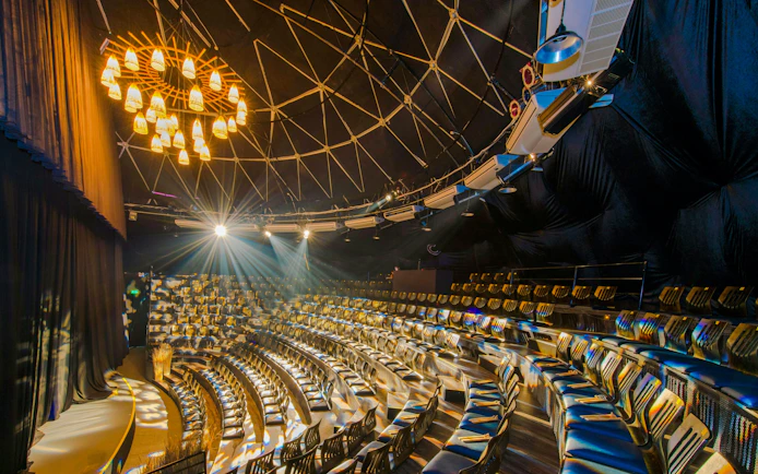 Teh Dar Vietnamese Bamboo Circus seating under iconic dome with stage lighting.