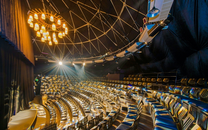 Teh Dar Vietnamese Bamboo Circus seating under iconic dome with stage lighting.
