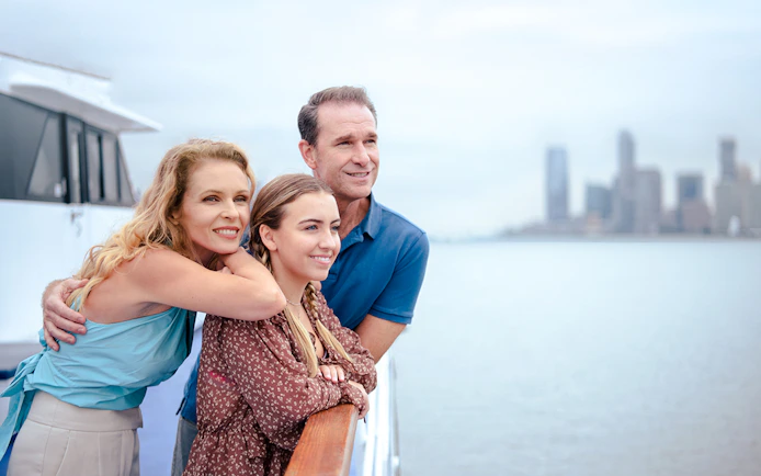 Family enjoying New Jersey Signature Cruise with city skyline in background.