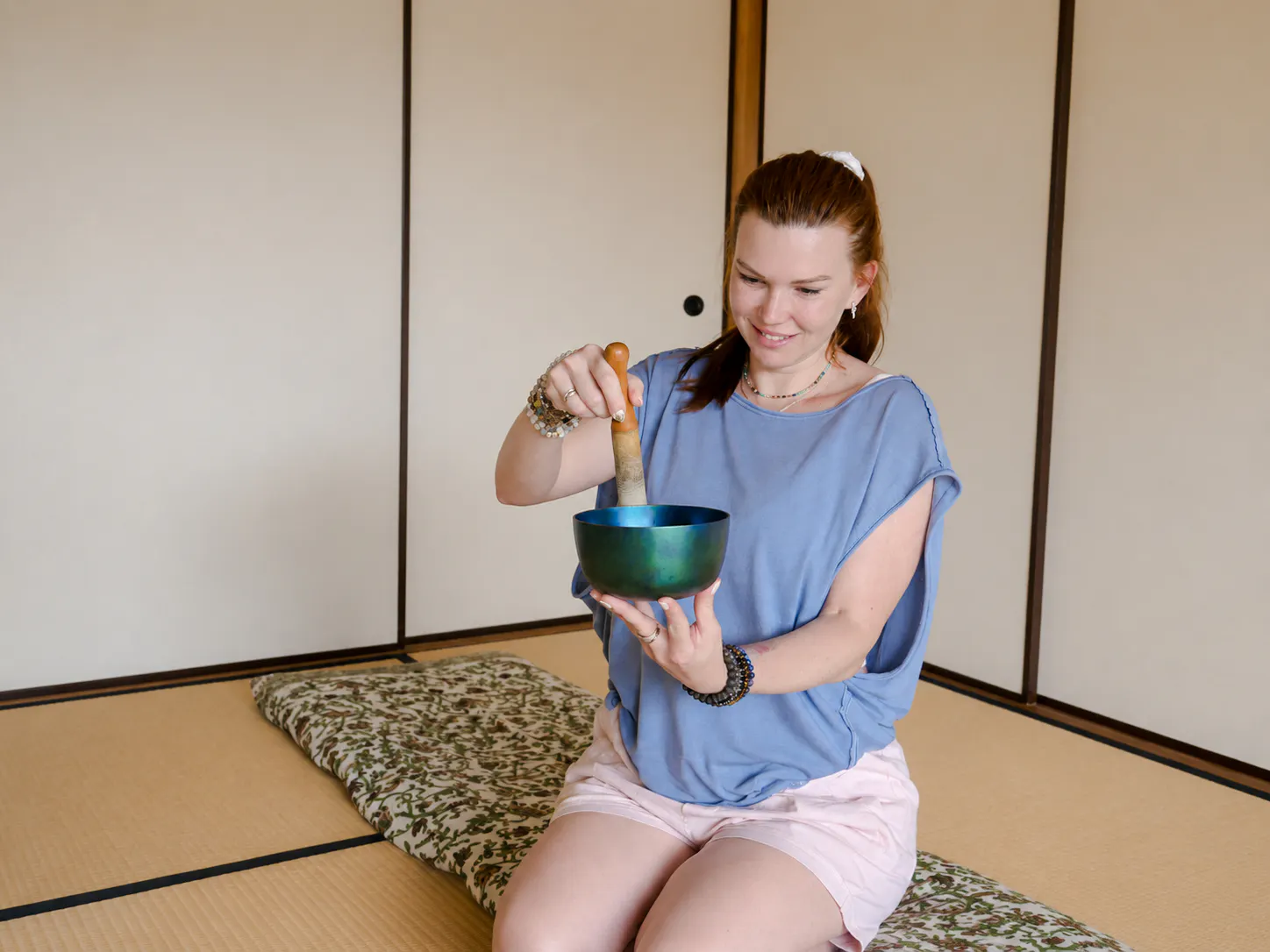 Person using a singing bowl during a Japanese sound bath session in Kyoto.