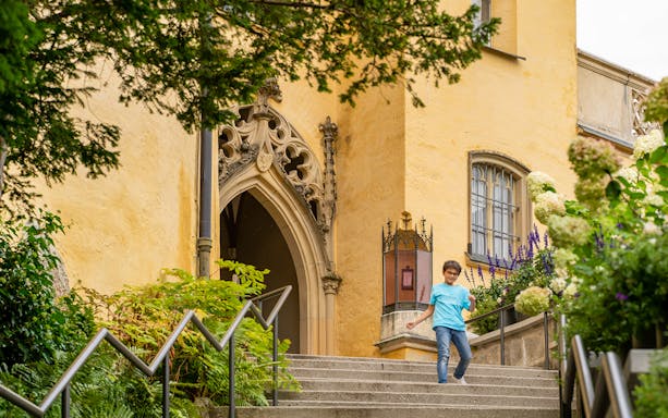 Child walking down steps at Hohenschwangau Castle entrance, Germany.