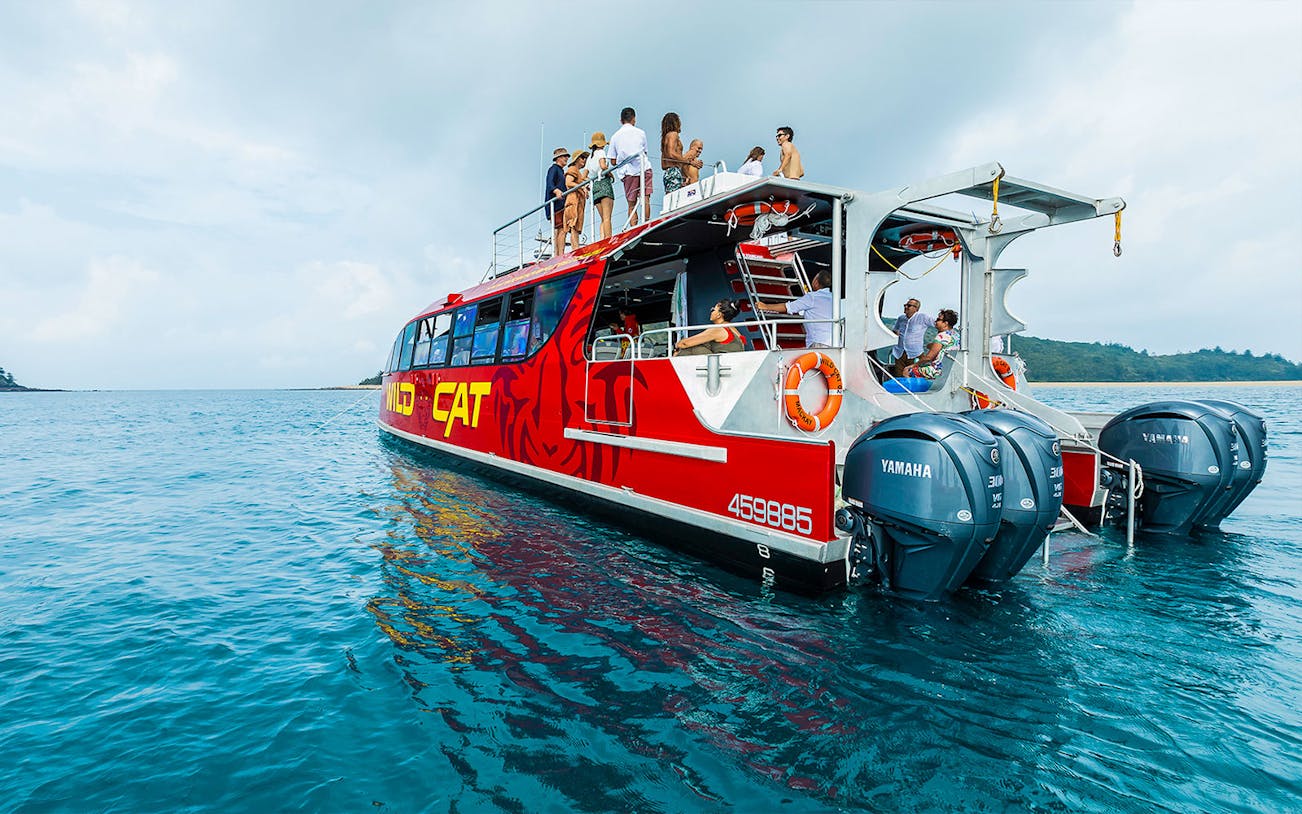 Tourists on the Wildcat Mackay boat enjoying an all-inclusive day tour on the ocean.
