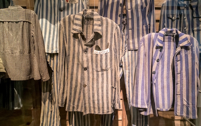 Striped prisoner uniforms displayed at Auschwitz Birkenau Memorial and Museum.