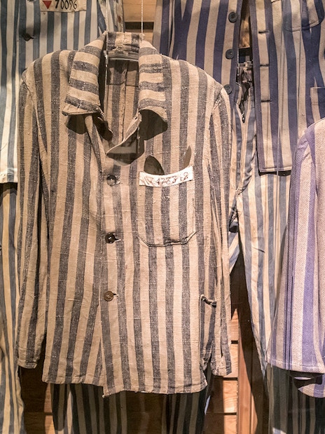 Striped prisoner uniforms displayed at Auschwitz Birkenau Memorial and Museum.