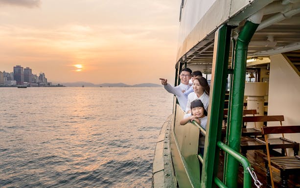 Family enjoying sunset on Star Ferry Harbor Tour in Hong Kong.
