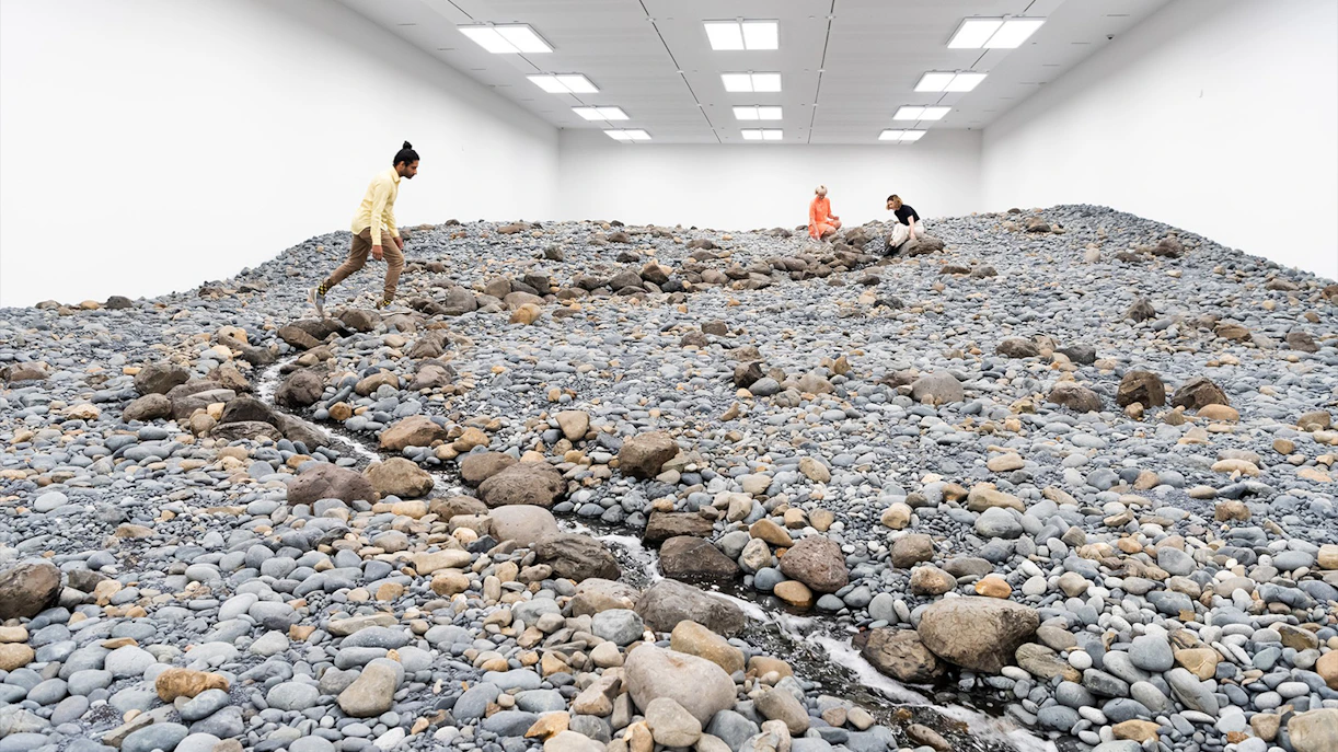 Visitors exploring Olafur Eliasson's rocky landscape installation at Gallery of Modern Art.