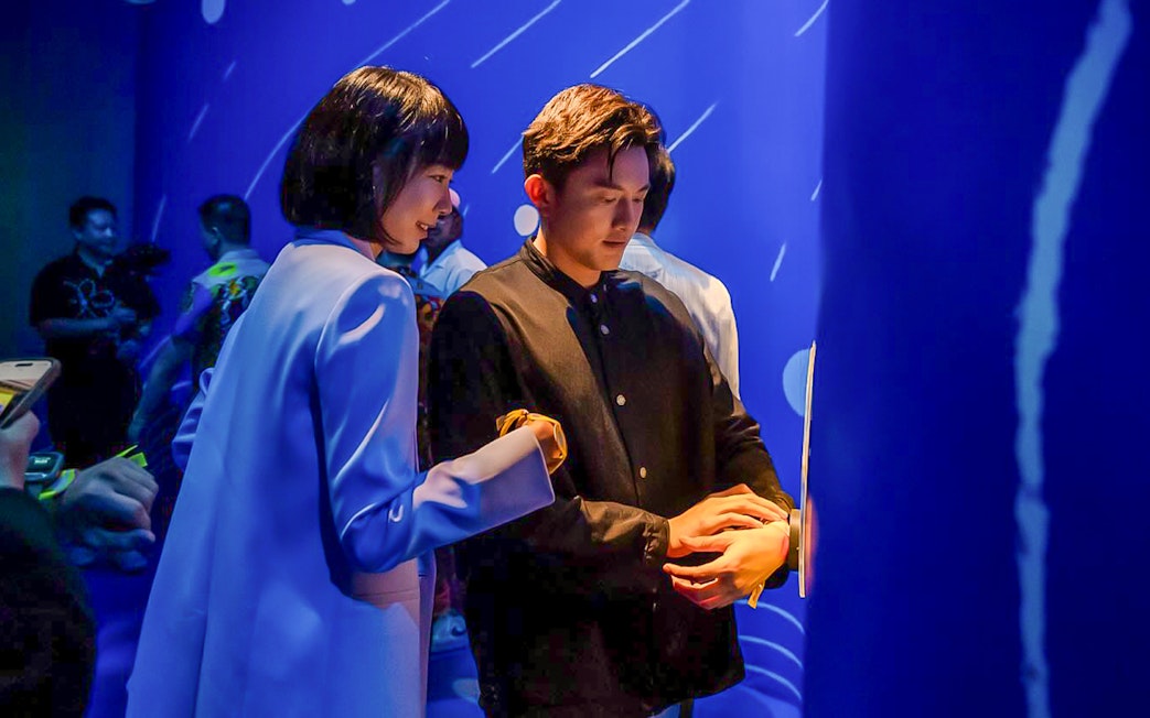 Man and woman engaging with blue interactive exhibit.