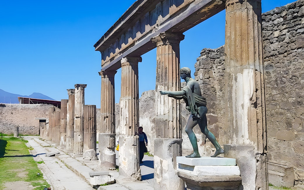 Ancient columns and statue at Pompeii ruins, Italy.