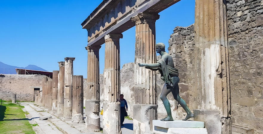 Ancient columns and statue at Pompeii ruins, Italy.