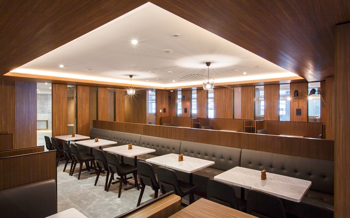 Plaza Premium Lounge seating area with tables and chairs in Melbourne airport.