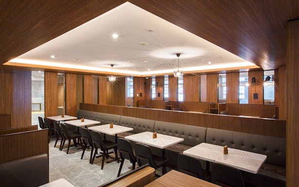Plaza Premium Lounge seating area with tables and chairs in Melbourne airport.