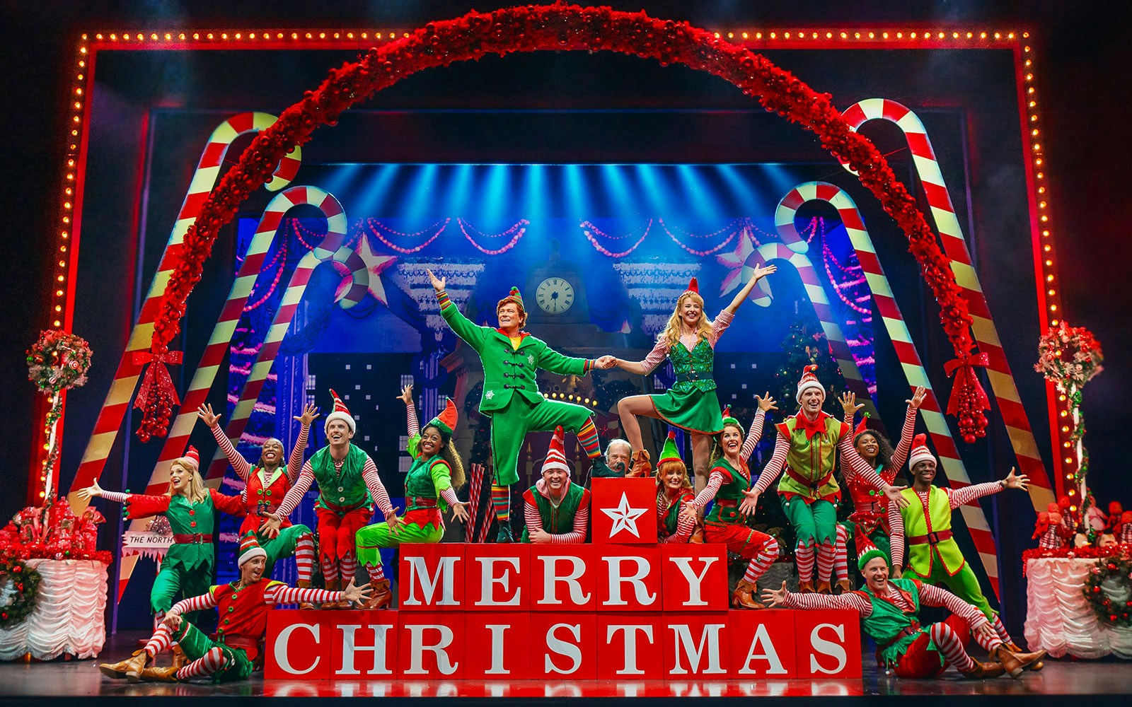 Elf The Musical stage performance with actors in festive costumes at a theater.