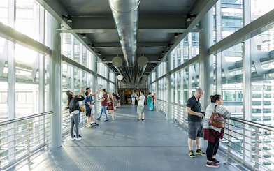 Visitors on the SkyBridge at Petronas Twin Towers, Kuala Lumpur, taking photos and enjoying views.