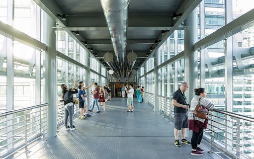 Visitors on the SkyBridge at Petronas Twin Towers, Kuala Lumpur, taking photos and enjoying views.