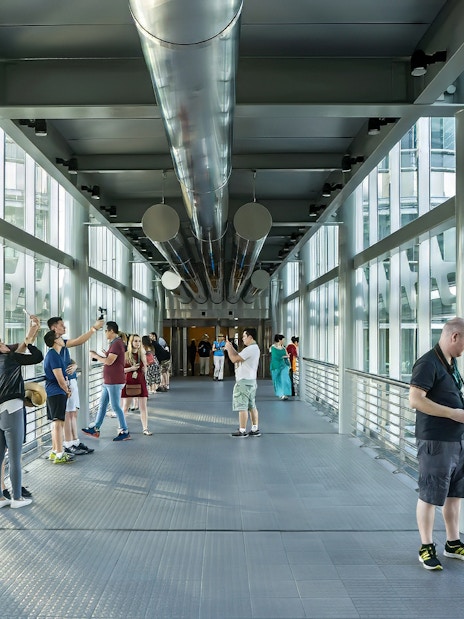 Visitors on the SkyBridge at Petronas Twin Towers, Kuala Lumpur, taking photos and enjoying views.