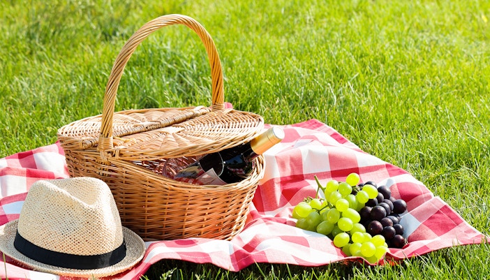 Picnic baskets, with grapes spread on a bedsheet