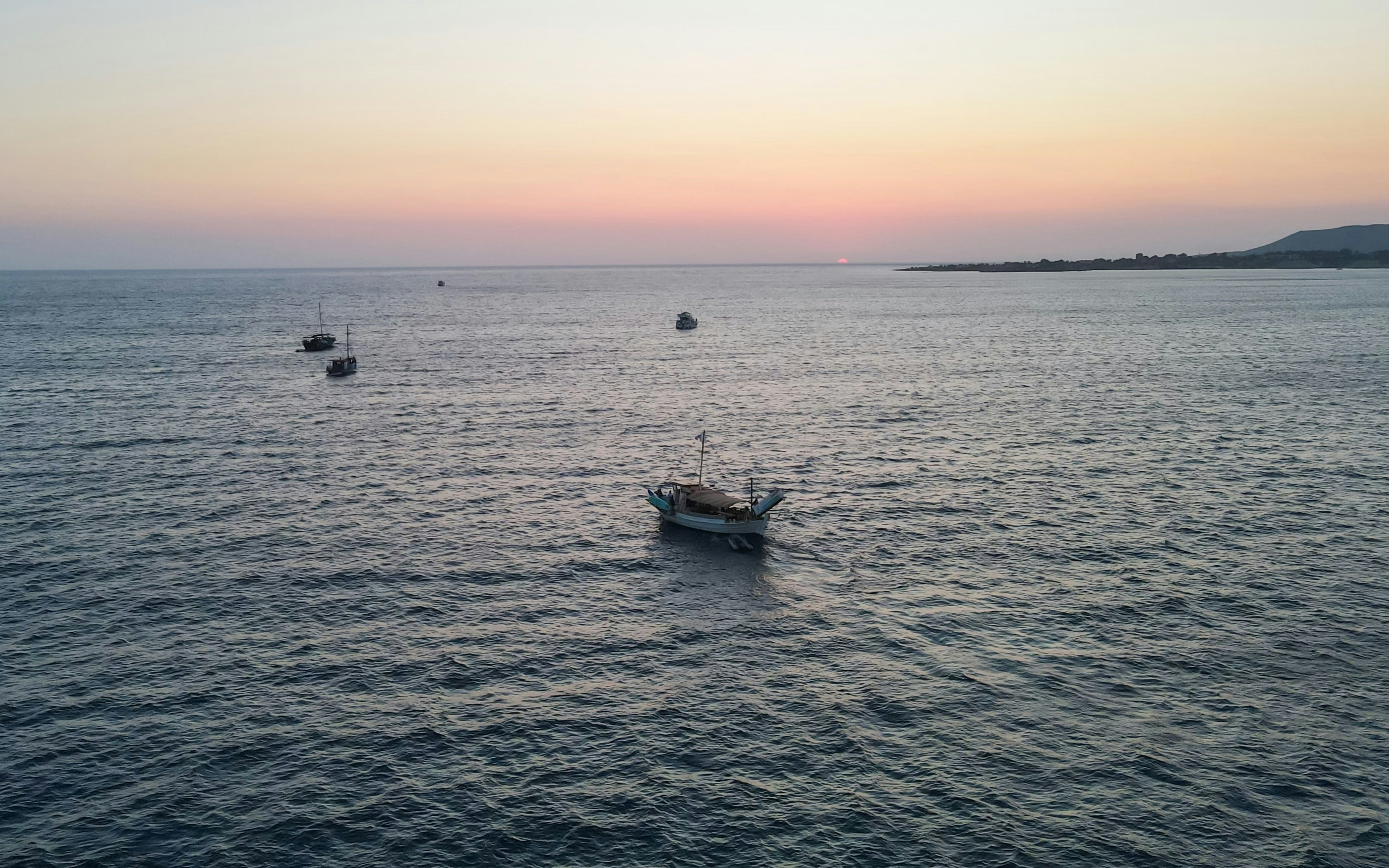 Boats sailing during sunset on a cruise from Kefalonia.