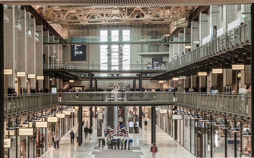 Interior view of New Battersea Power Station with shops and walkways.