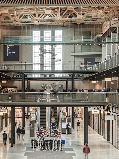 Interior view of New Battersea Power Station with shops and walkways.