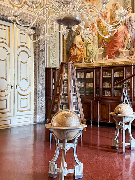 Royal Palace of Caserta library with globes and bookshelves.