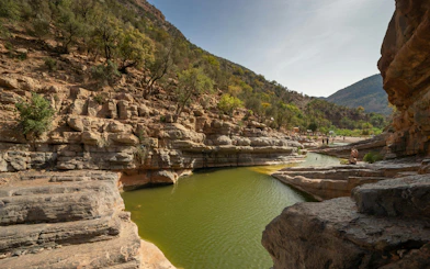 Rocky landscape with green water pools in Paradise Valley, surrounded by trees and hills.