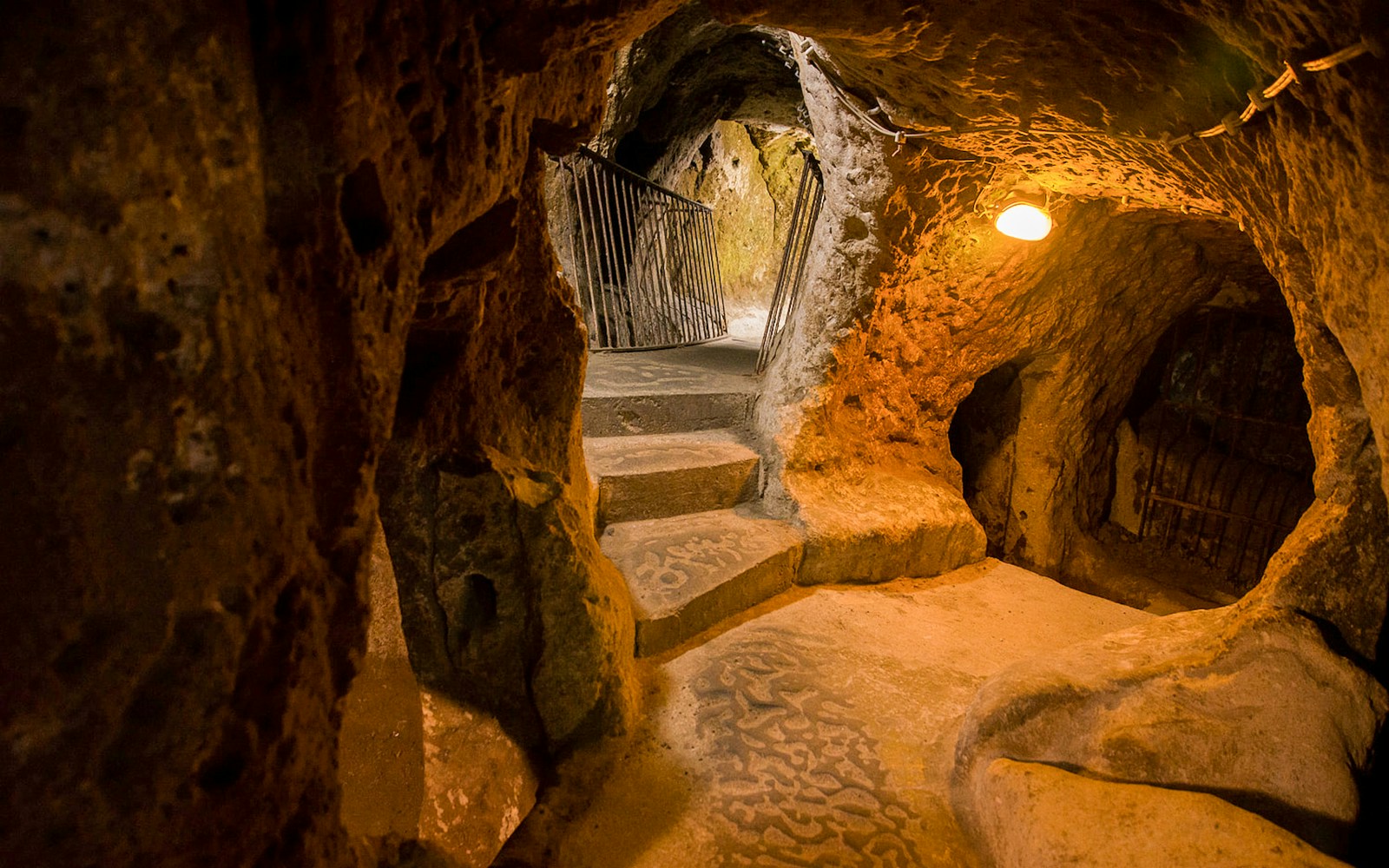 Derinkuyu underground cave city passage with stone steps and rock walls.