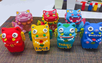 Colorful terracotta Shisa statues from Okinawa displayed on a mat.