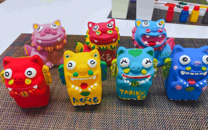 Colorful terracotta Shisa statues from Okinawa displayed on a mat.