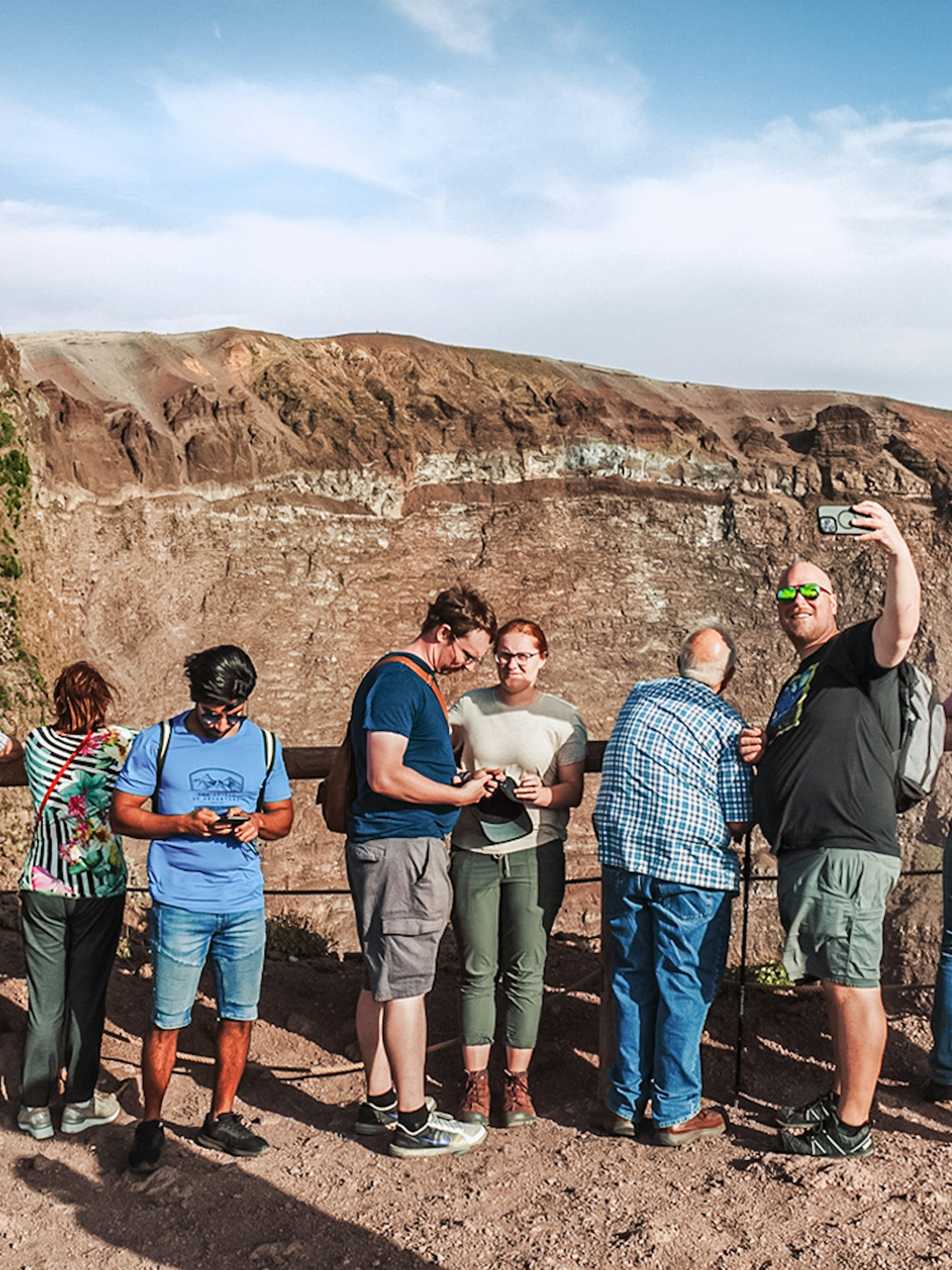 Tourists taking photos at the crater of Mount Vesuvius, Italy.