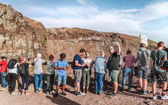 Tourists taking photos at the crater of Mount Vesuvius, Italy.