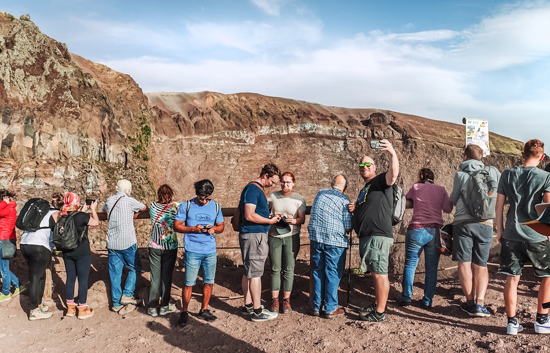 Tourists taking photos at the crater of Mount Vesuvius, Italy.