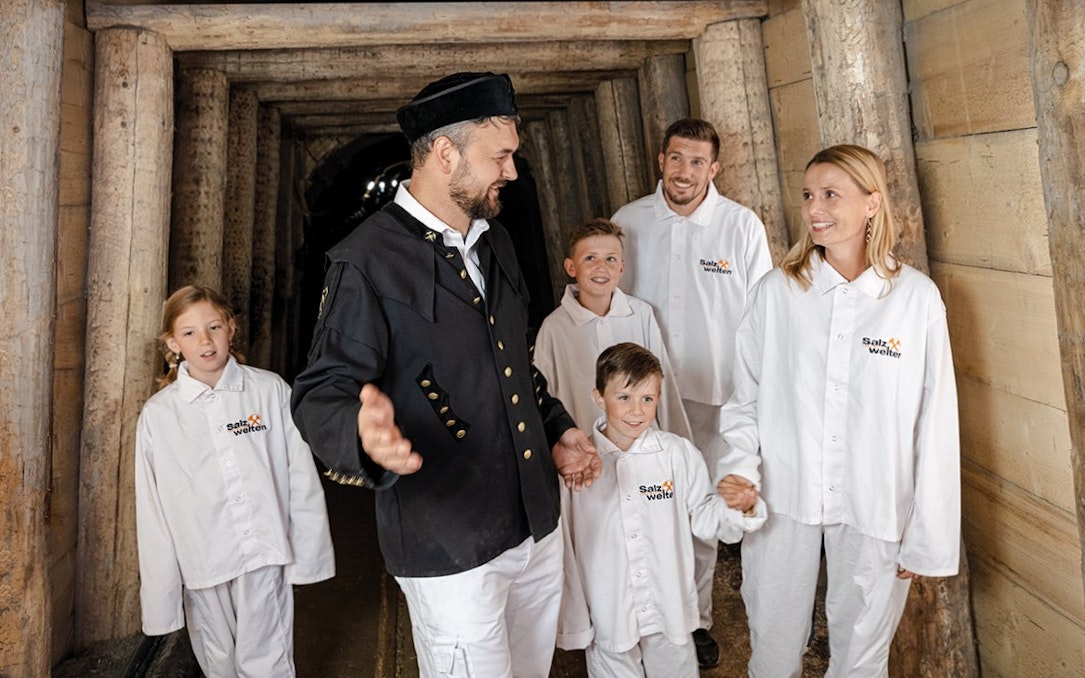 Tour group exploring Hallein salt mines in Salzburg with a guide.